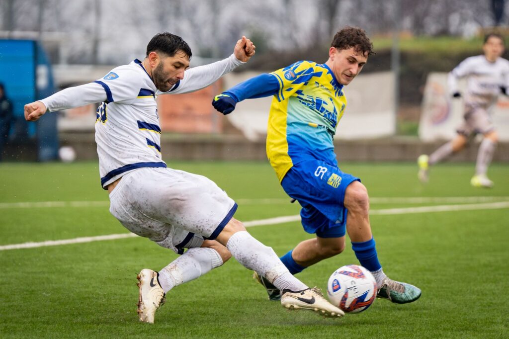 Two soccer players in action during a competitive match on the field.