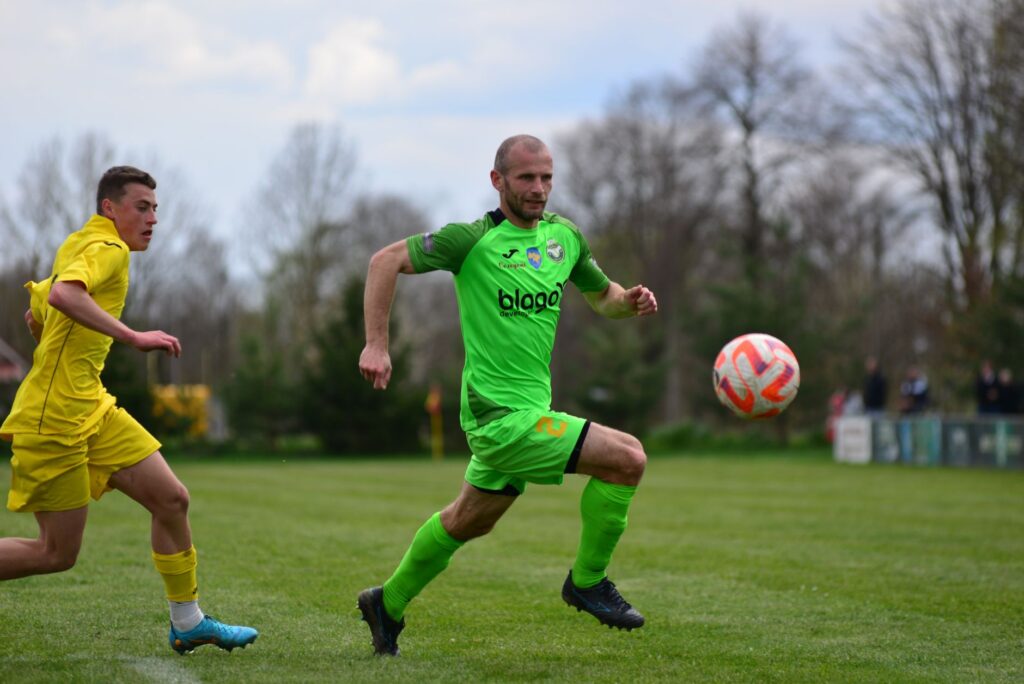 Soccer players in action during a match on a grassy field, displaying athleticism and concentration.