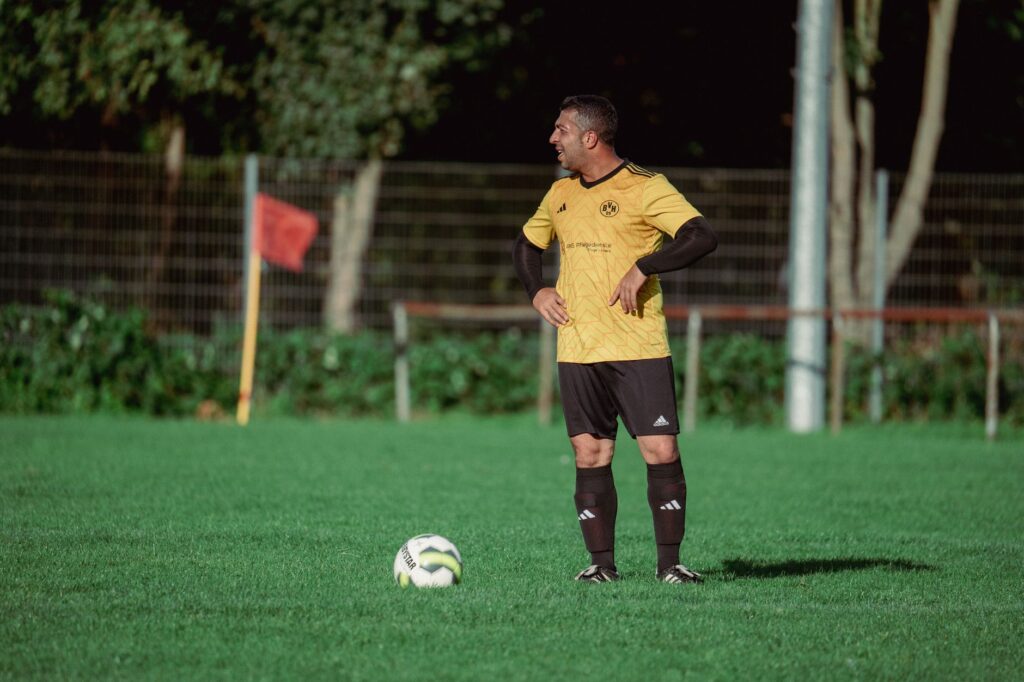 Adult soccer player on a sunny outdoor field preparing for play.