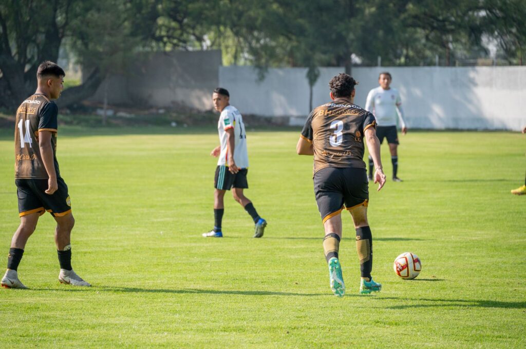 Players in action during a soccer match on a sunny day, highlighting teamwork and sportsmanship.