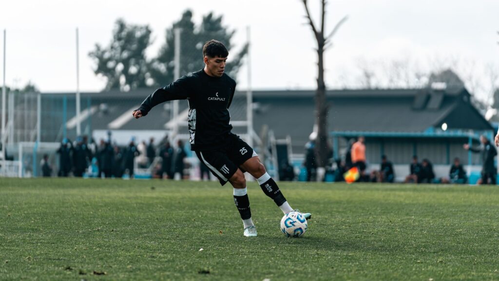 A young soccer player in action during practice on a grassy field outdoors.